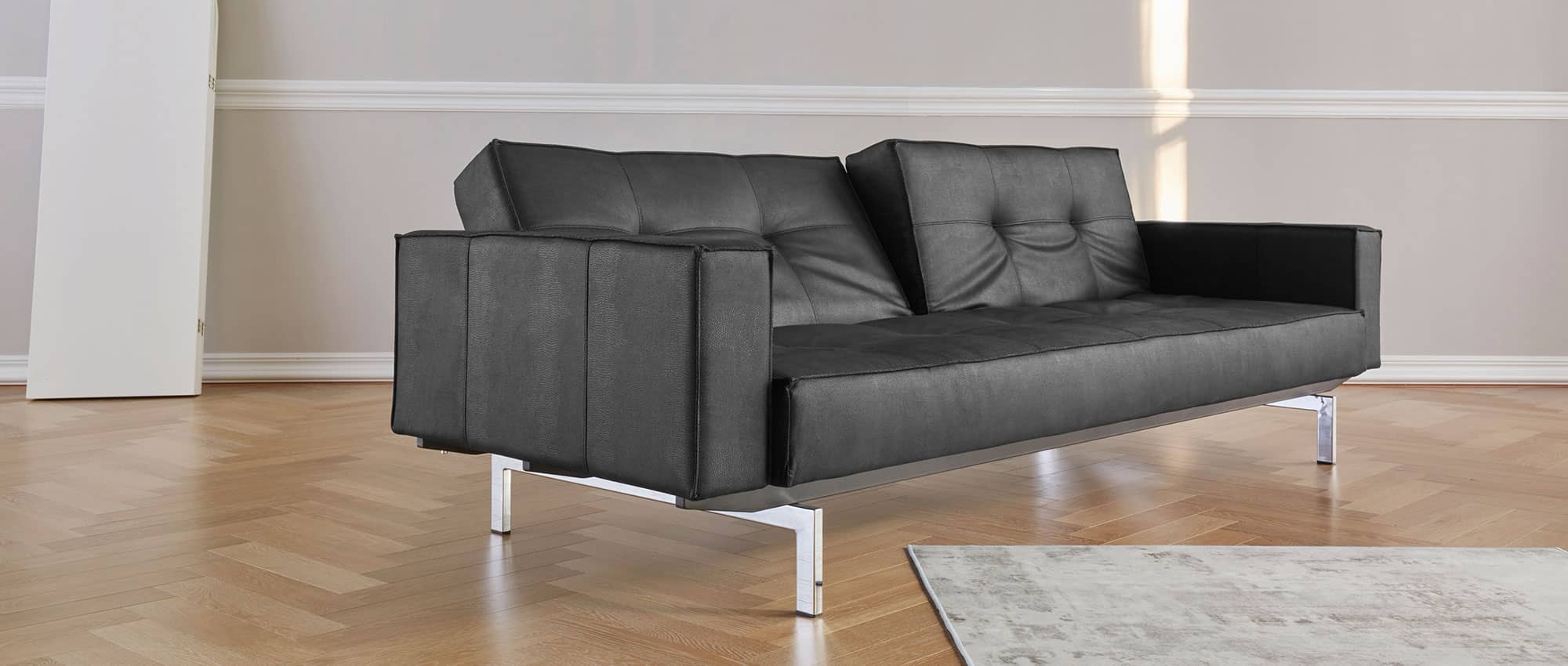 Innovation SPLITBACK Schlafsofa mit Armlehnen als Sonderanfertigung in Kunstleder Faunal Black (550) und mit Chromfüßen