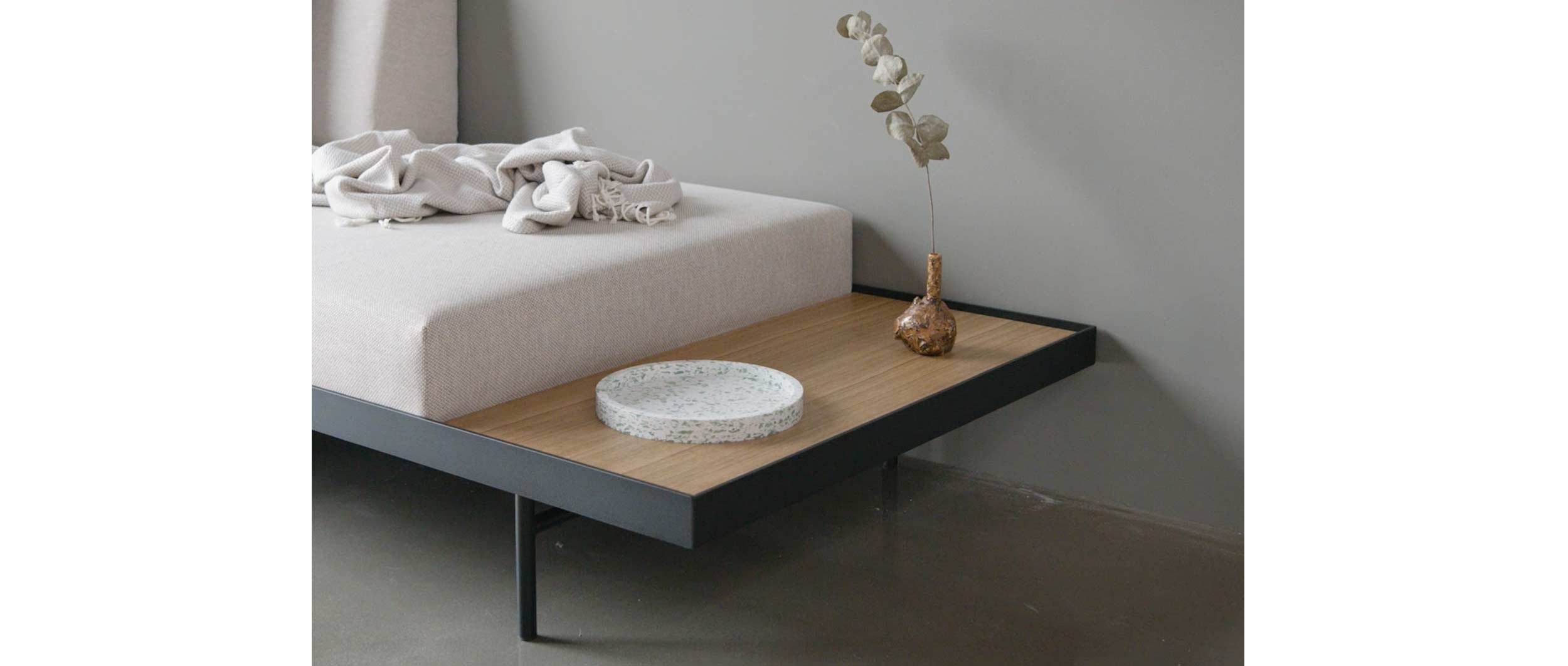 Das PURI Daybed mit dem Holztisch aus Eichenholz-Furnier - perfekt als Ablage für z.B. Tassen, Bücher etc.