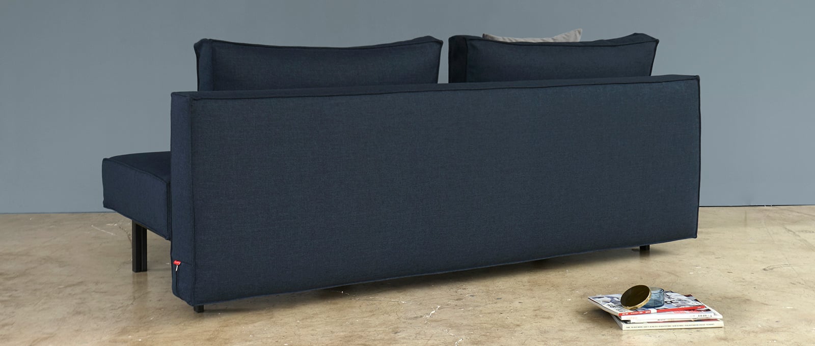 Durch die komplett bezogene Rückseite kann das SLY Schlafsofa auch freistehend im Raum genutzt werden