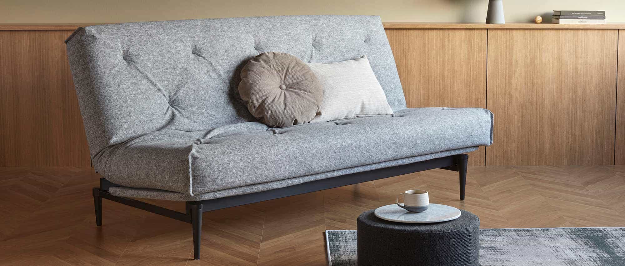 Das COLPUS Schlafsofa mit schwarzen Holzfüßen, festversteppter Matratze und Gestellbezug für die Sitzfläche (optional)