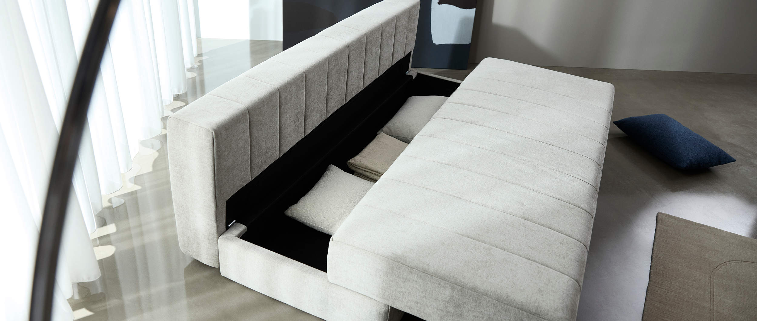 Der im AKELLO Sofa integrierte Bettkasten bietet viel Stauraum