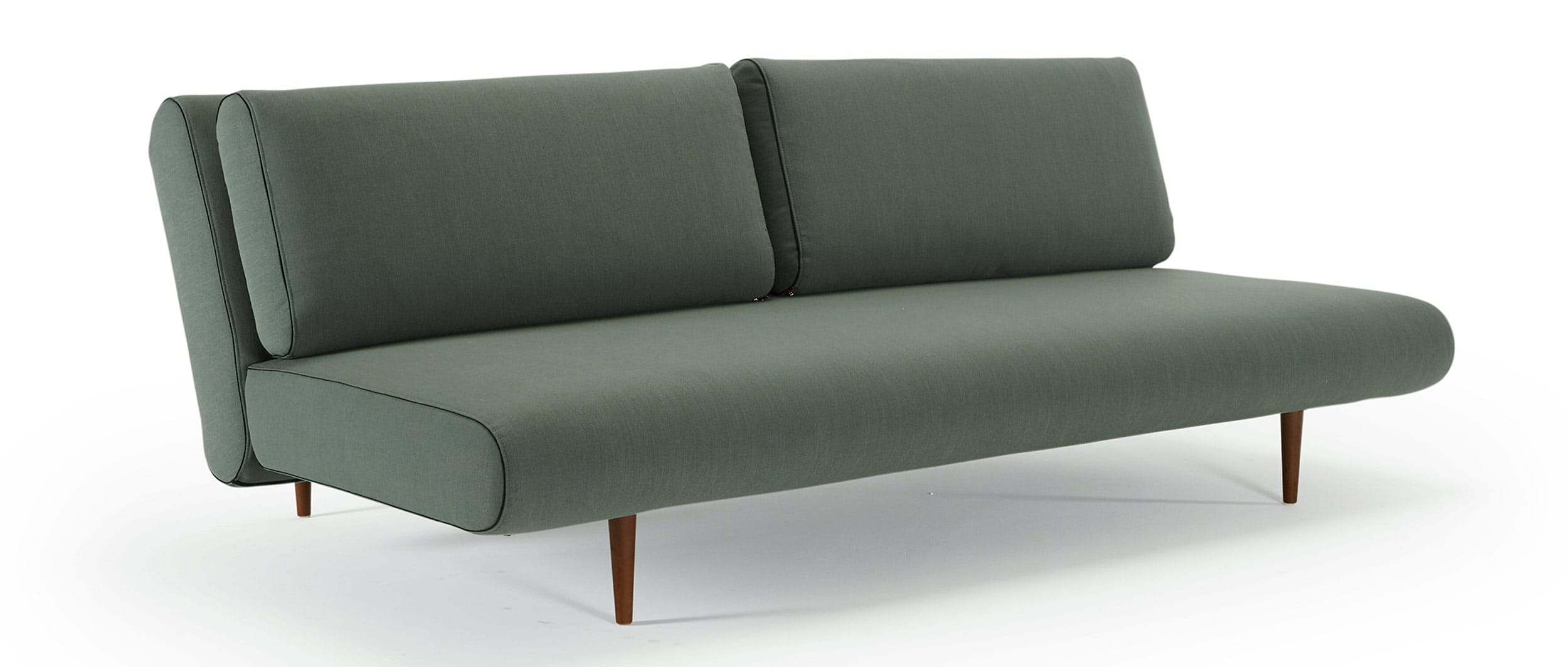 Das UNFURL LOUNGER Schlafsofa von Innovation im Stoff Elegance Green (518) und mit dunkelbraun gebeizten Styletto Holzfüßen