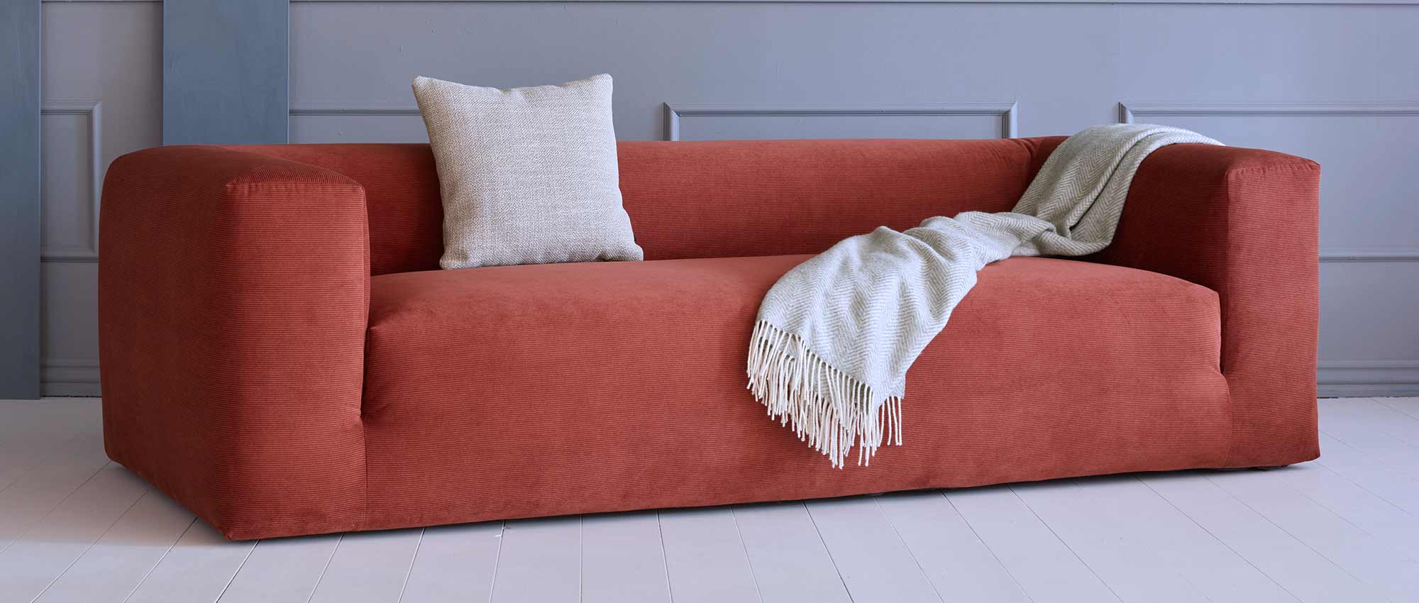 Das AALBORG 3-Sitzer Lounge Sofa im skandinavischen Design mit breiten Armlehnen und ohne die Rückenkissen