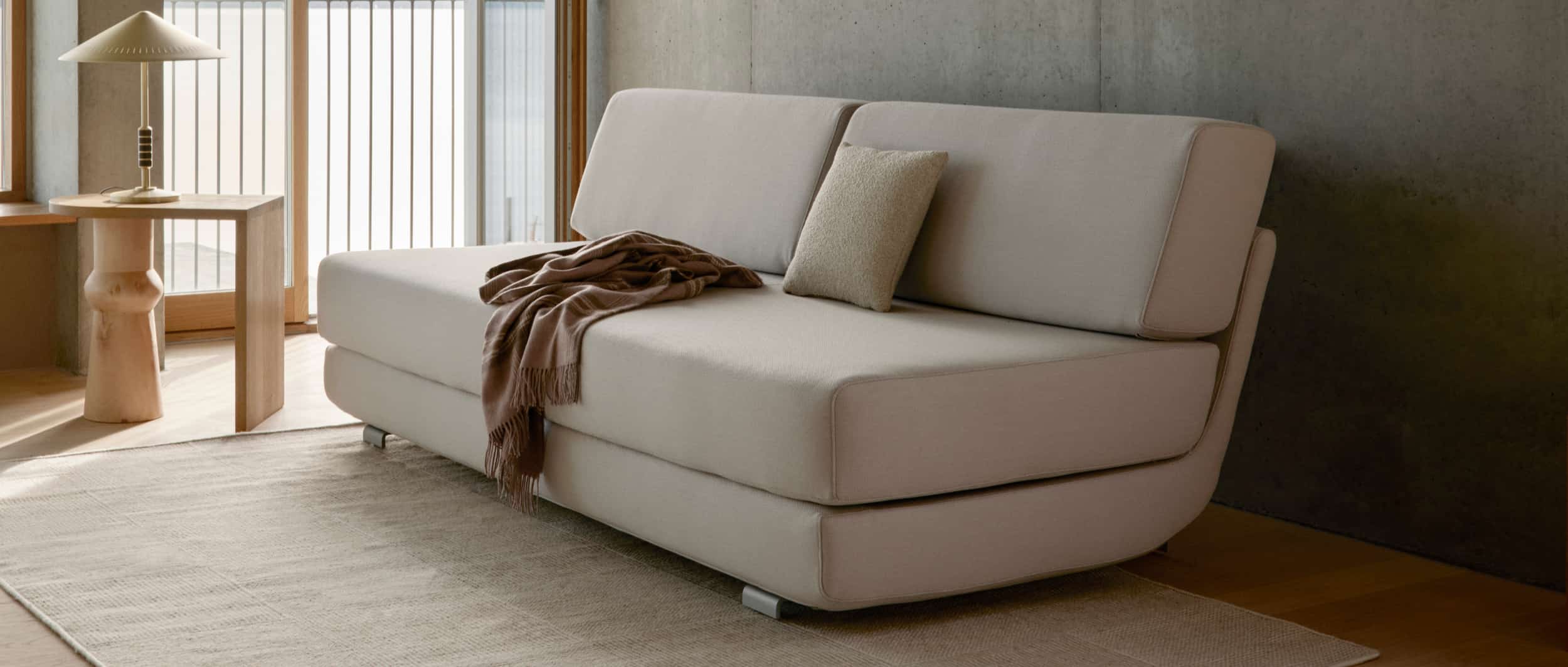Das Schlafsofa LOUNGE PLUS von Softline ist mit aluminiumfarbigen oder schwarzen Metallfüßen erhältlich