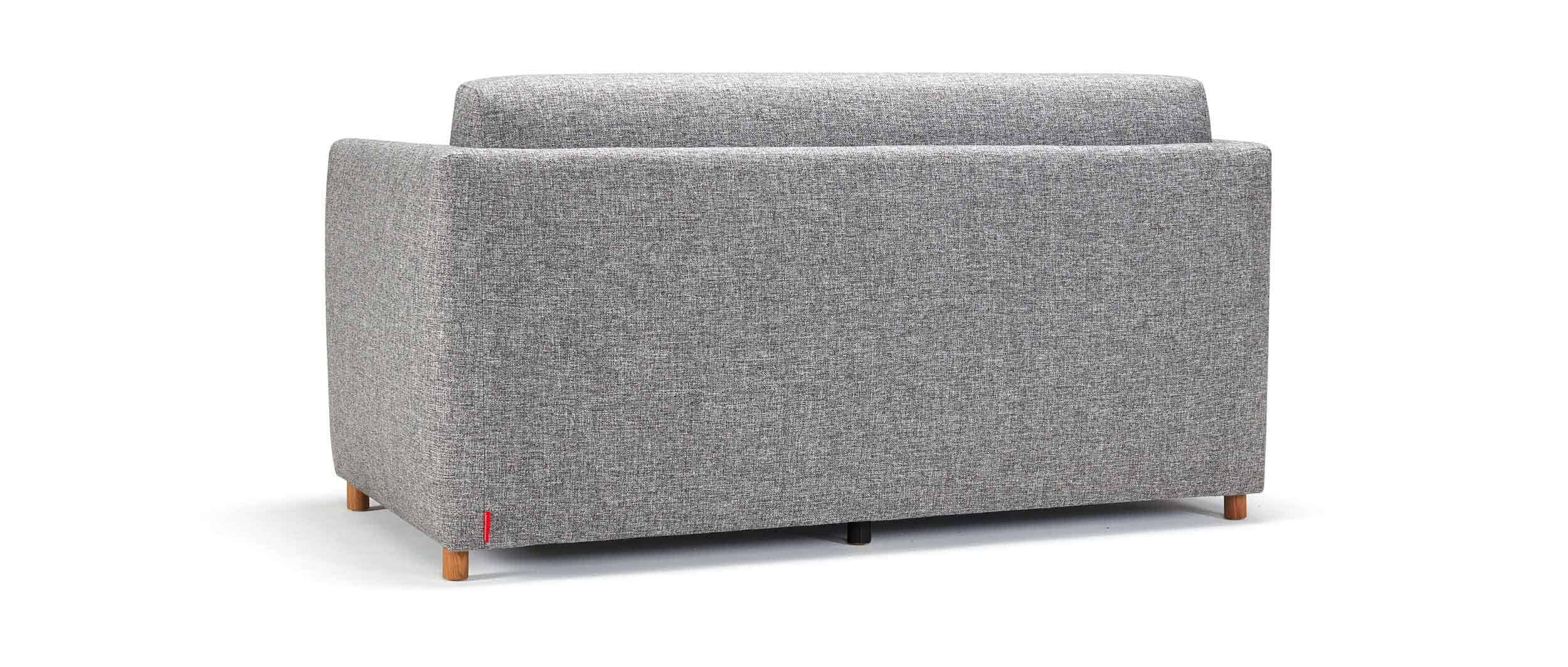 Das OLAN Schlafsofa mit Polsterarmlehnen kann auch freistehend im Raum genutzt werden