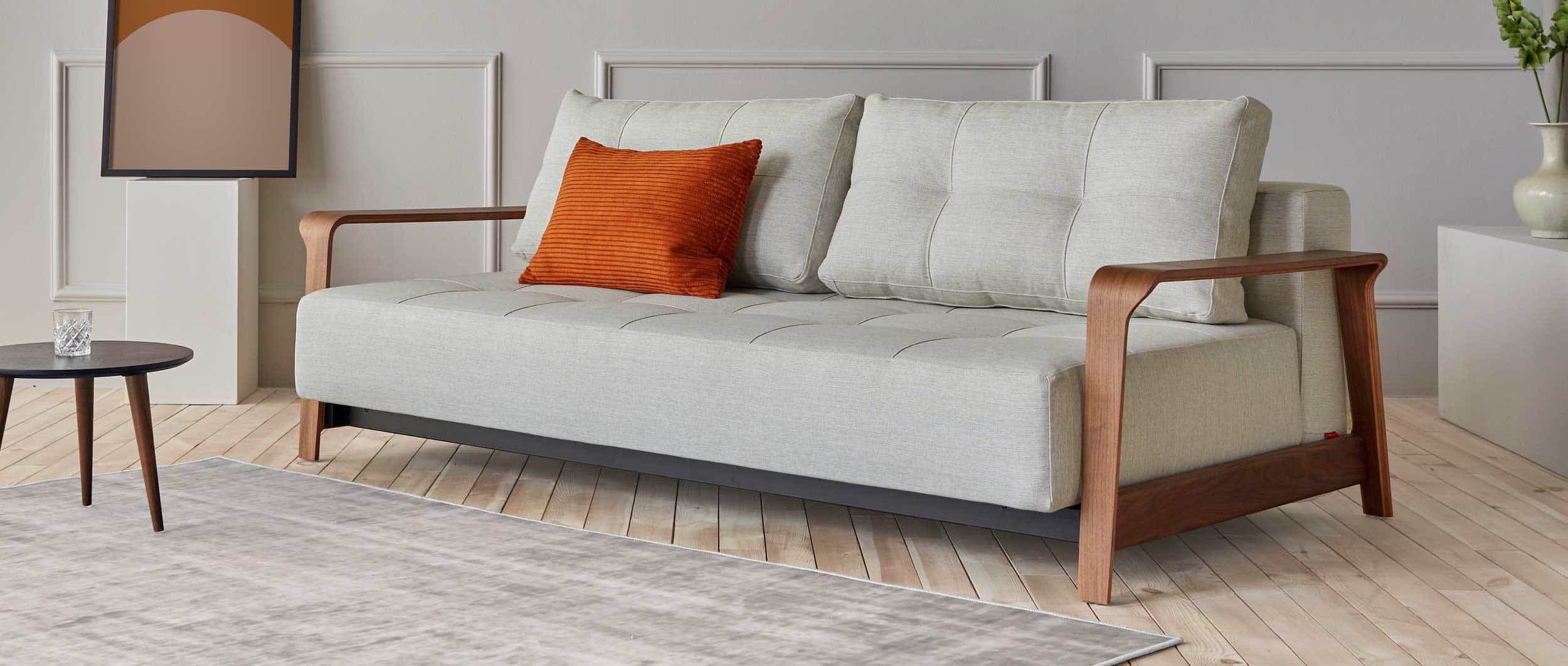 Mit schöner Versteppung und den Walnuss-Armlehnen ist das RAN DELUXE Schlafsofa ein stilvoller Hingucker
