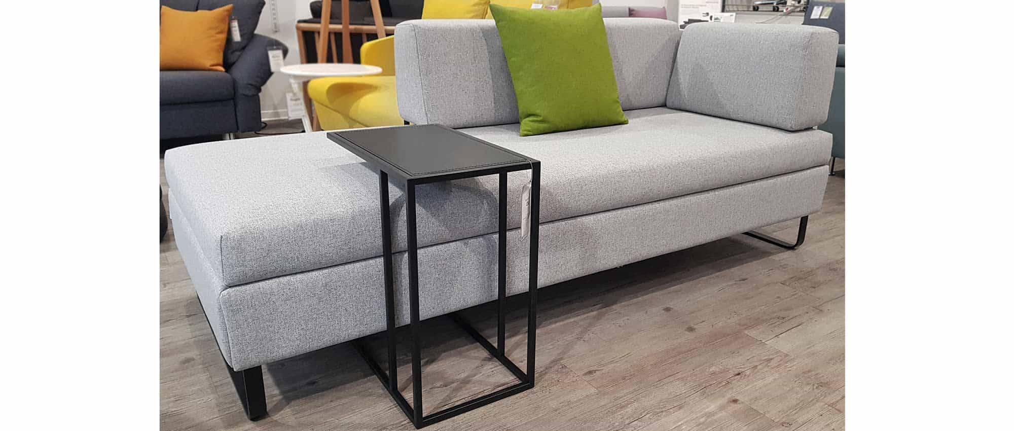 Der CLUB Tisch in mattschwarz kombiniert mit den schwarzen Metallkufen - am Beispiel des DOPPIO Schlafsofas (Stoff Sole - Hellgrau - (442)) gezeigt