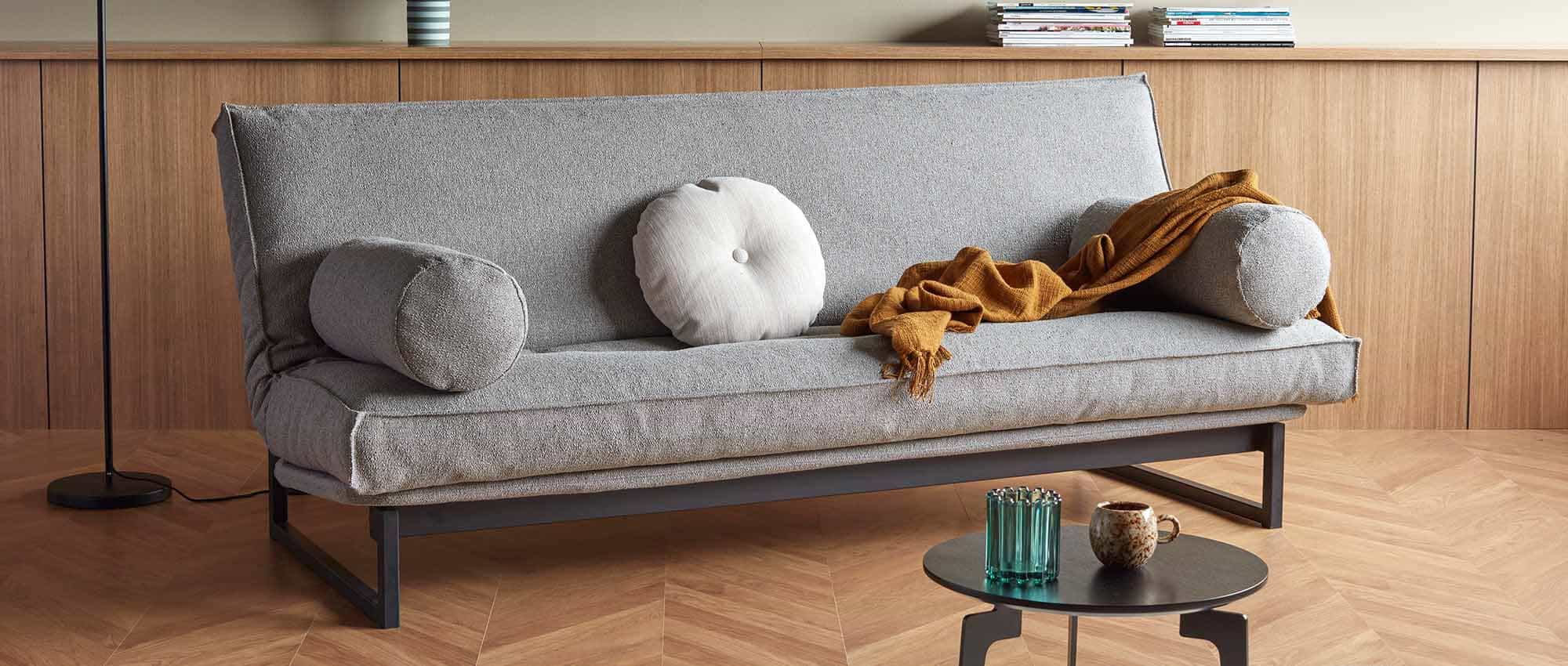 Das FRACTION Schlafsofa mit der Liegefläche ca. 120x200 cm, Stoff Bouclé Ash Grey (533) und mit ROLL Kissen als Armlehnen (optional)