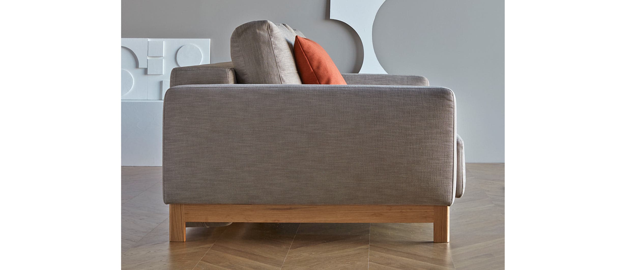 Das PYXIS Schlafsofa im skandinavischen Design mit Polsterarmlehnen und hellen Holzfüßen aus Eiche