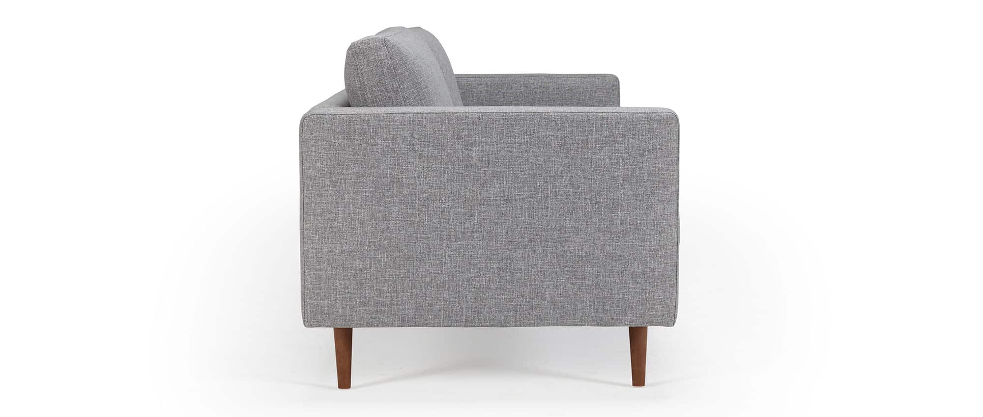 Das HALMSTAD Sofa hat Polsterarmlehnen und spitze Holzfüße