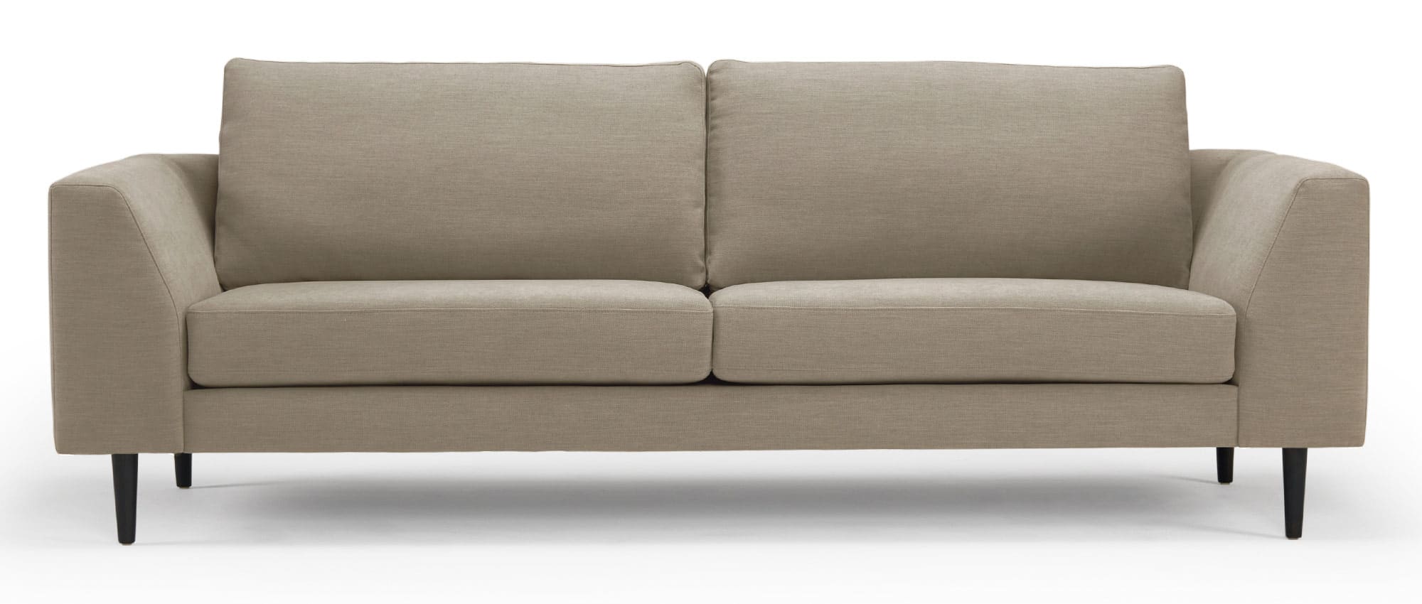 Das TRONDHEIM Designer Sofa hier als 3-Sitzer mit schrägen Armlehnen und spitzen Holzfüßen in Eiche schwarz - Stoff Uranus - Dusty Sand (571)