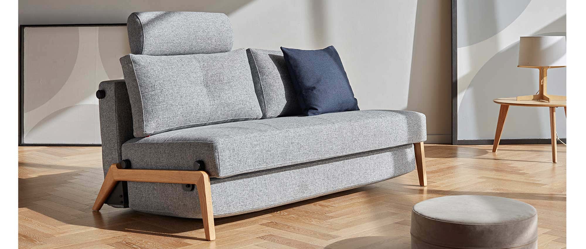 Das CUBED 02 Klappsofa 160 hier mit eleganten Eichenholzbeinen und der optionalen Kopfstütze FLIP