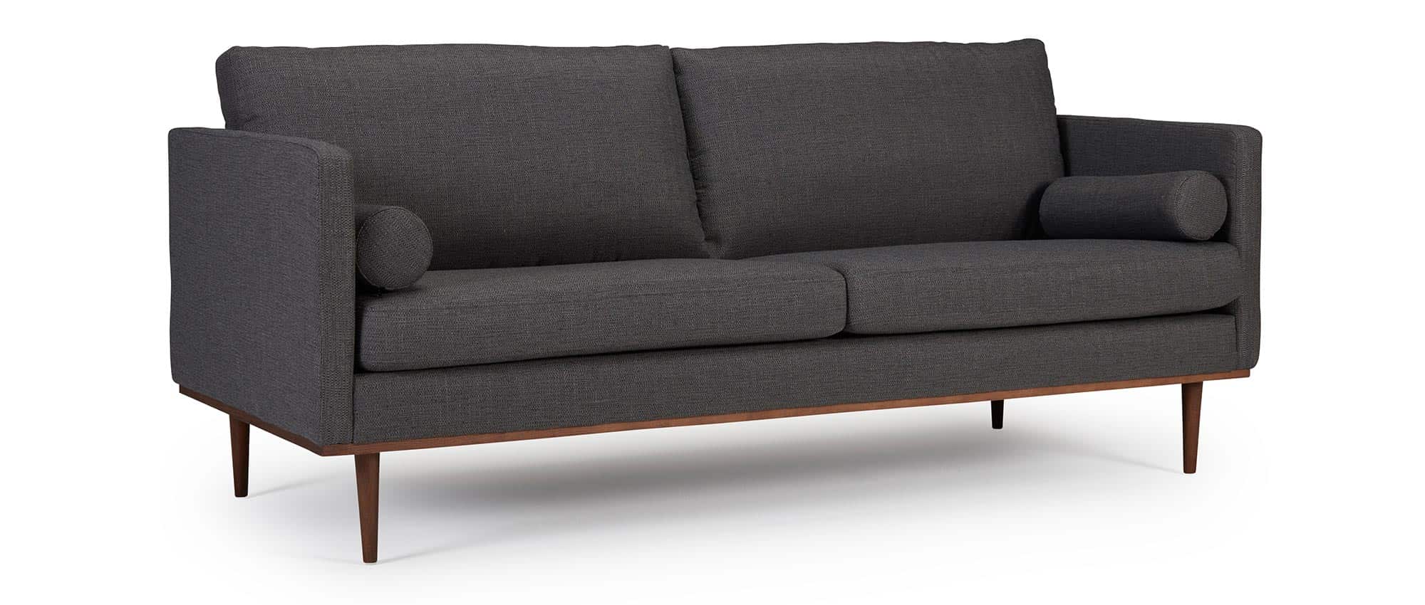 Das OSLO Designer Sofa mit Polsterarmlehnen, runden Seitenkissen und dunklen Holzfüßen