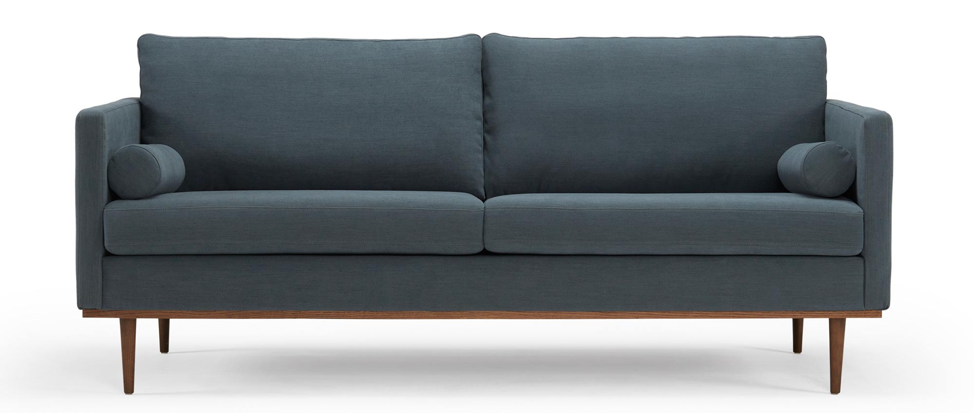 Das OSLO Designer Sofa mit Polsterarmlehnen, runden Seitenkissen und dunklen Holzfüßen