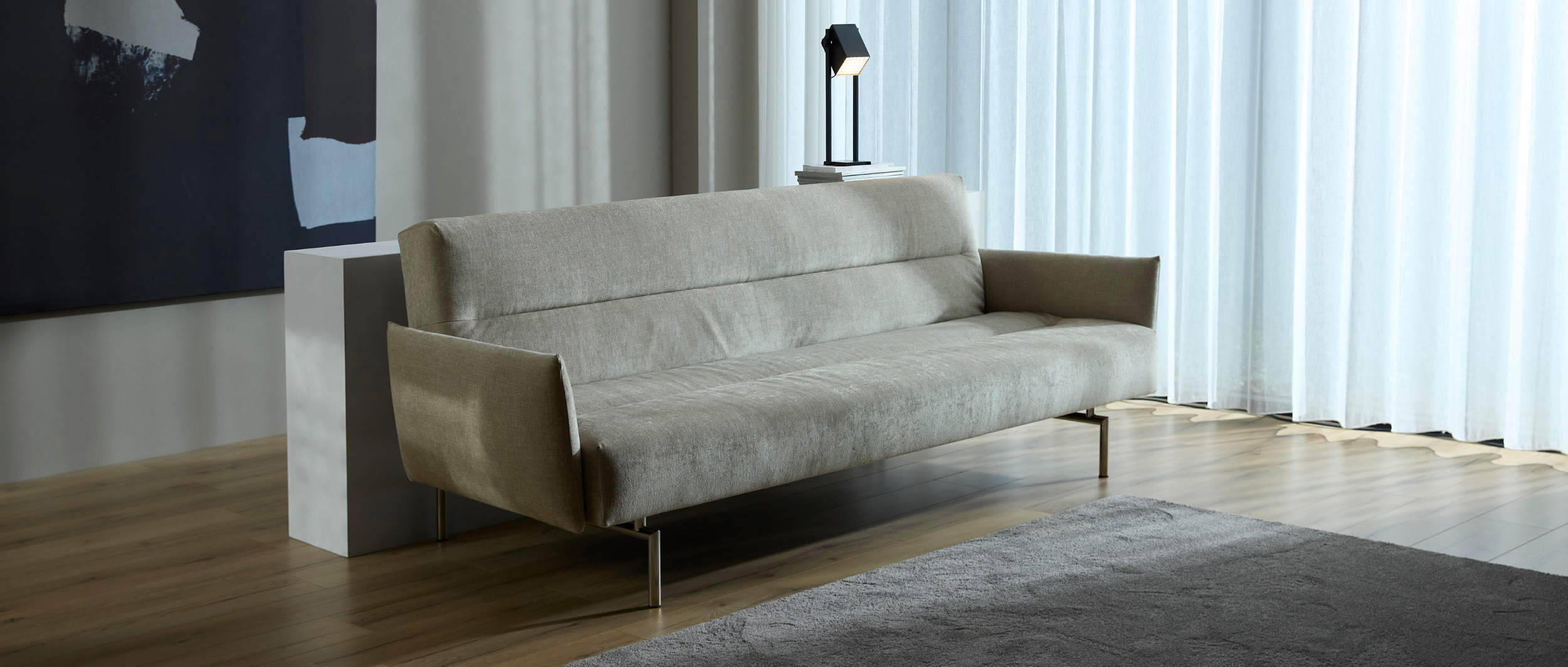 Die schlanke, strukturierte Silhouette des JILLIS Schlafsofas mit Armlehnen verleiht jedem Raum einen Hauch von Raffinesse